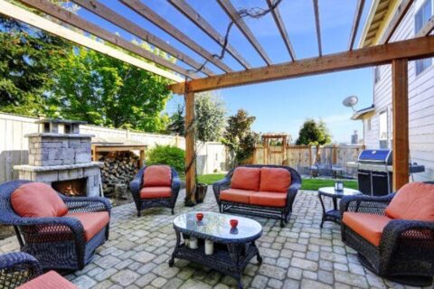 Patio furniture under a pergola by Thrive Landscape Services